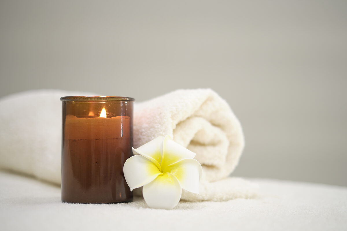 Candle with plumeria flower in a calming setting
